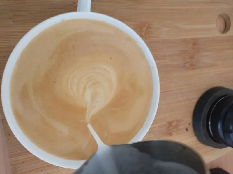 Den skummade mjölken hälls som en caffè latte i espresso