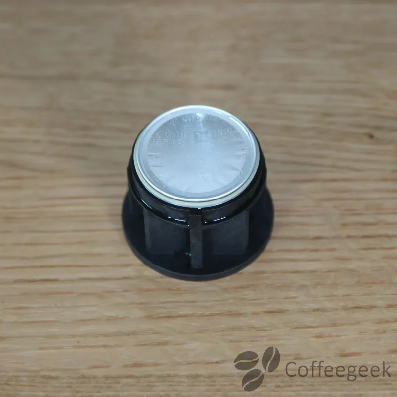 Genomborr toppen av Nespresso-kapseln genom att sätta in den i kapselhållaren.